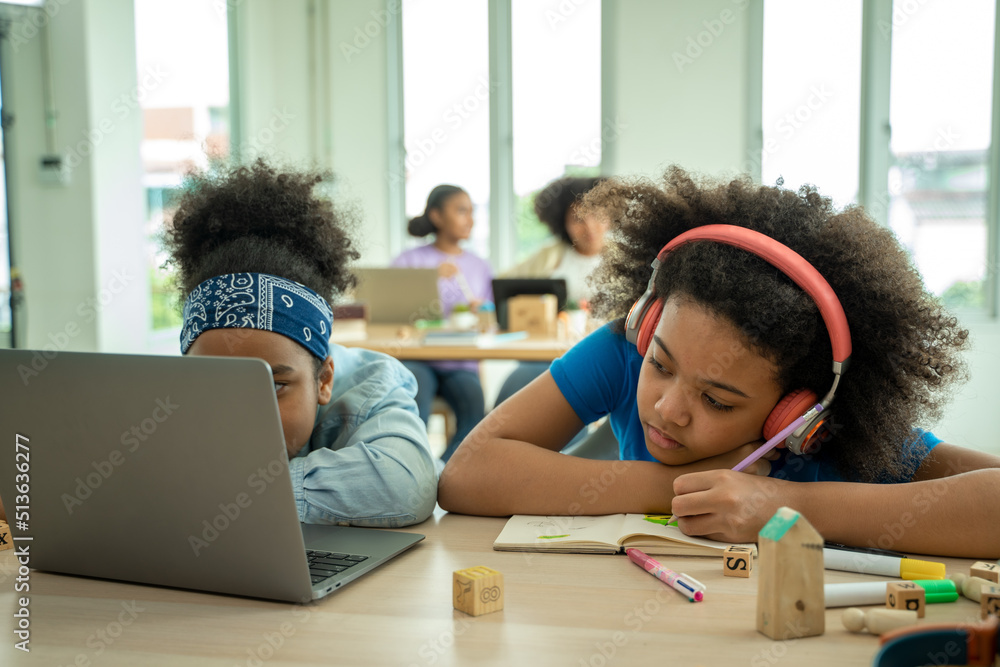 African American school children sleeping on desk at classroom,Girl is tired and sleeps.