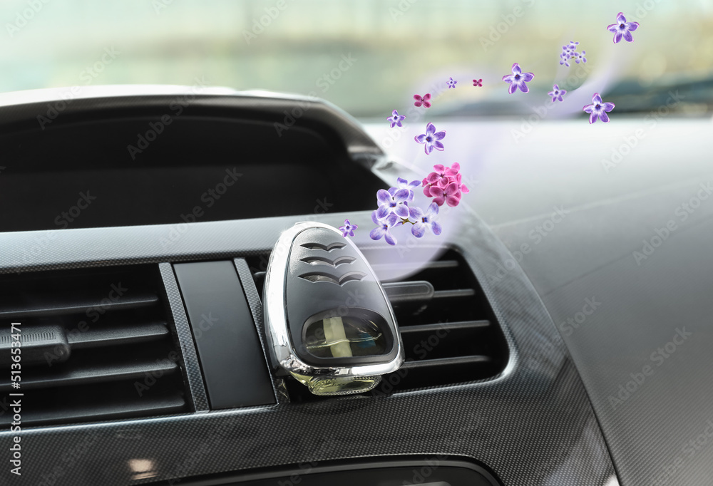 Aroma air freshener with flying fresh lilac flowers in car salon