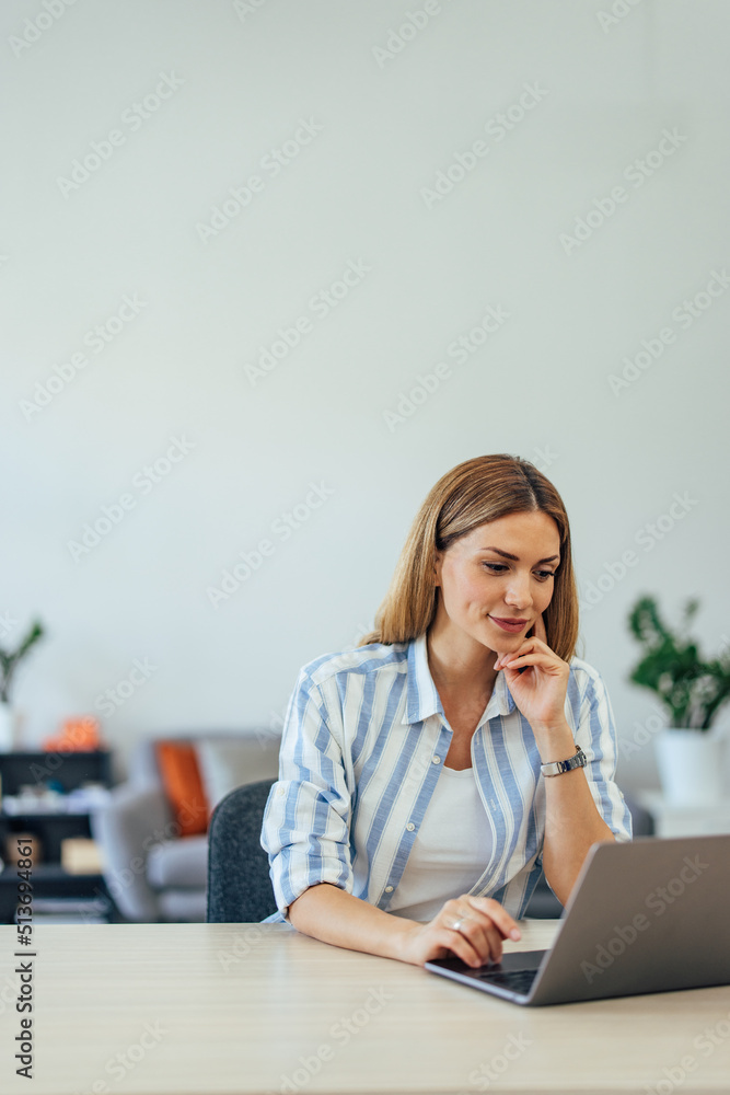 Focused businesswoman working over the laptop, looking concentrated.