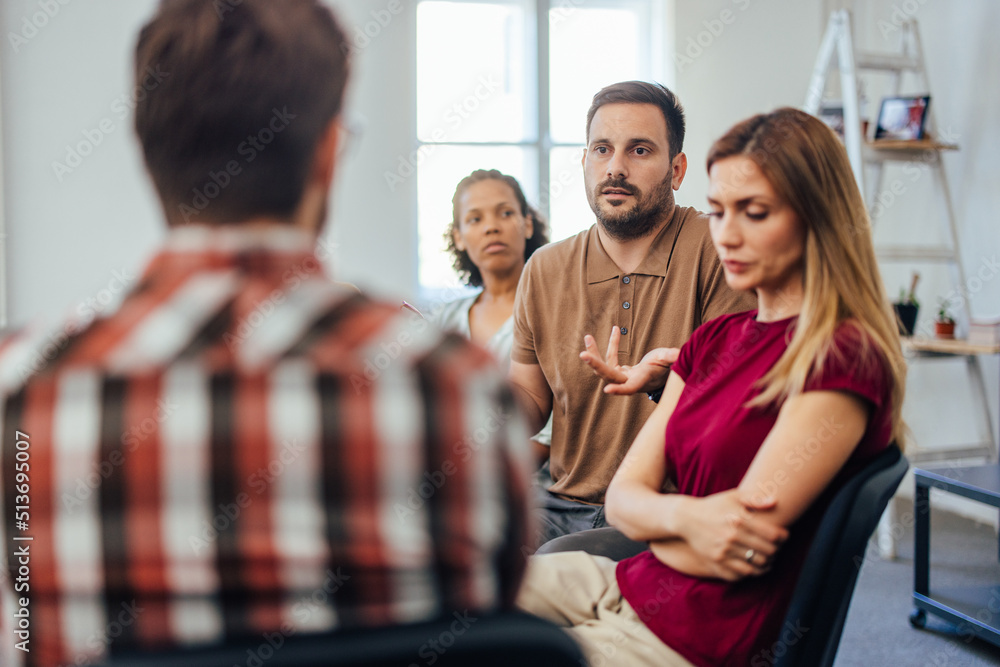 Adult man trying to explain his problem to the psychologist, during the group therapy.