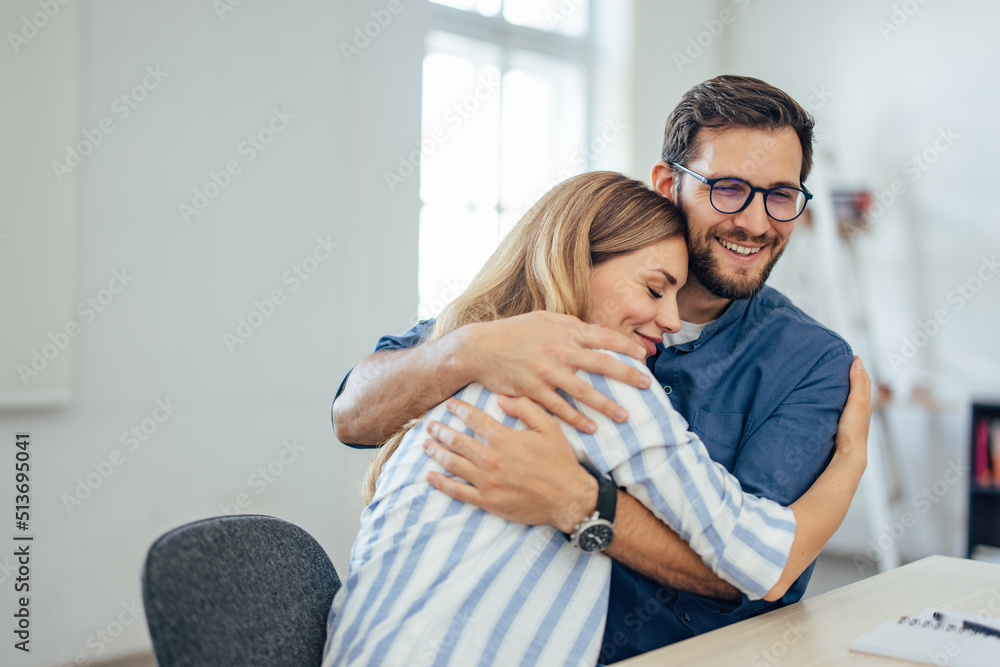 Two lovers in a hug, successfully sign the insurance contract.