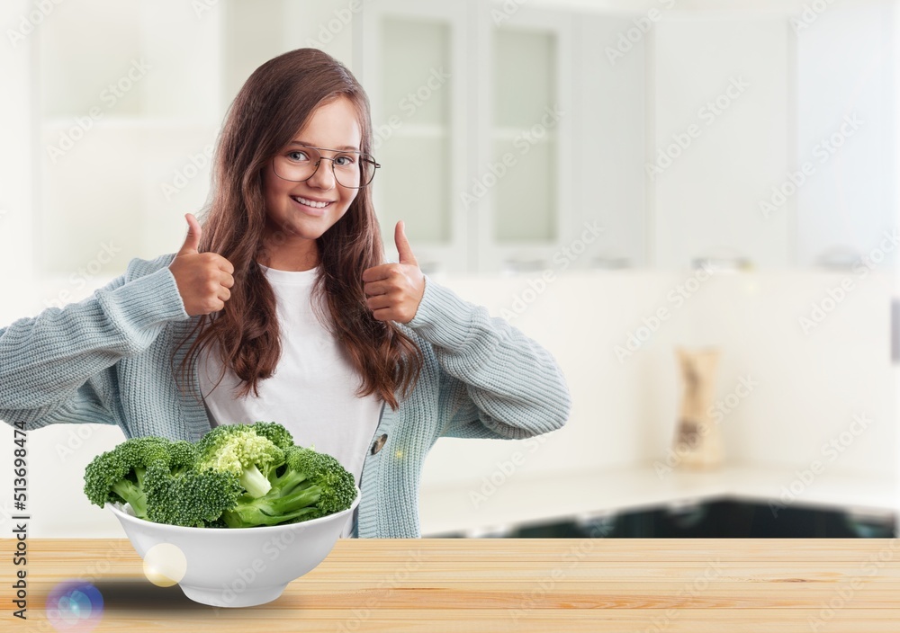 小女孩吃西兰花健康食品，盘子里有有机蔬菜。