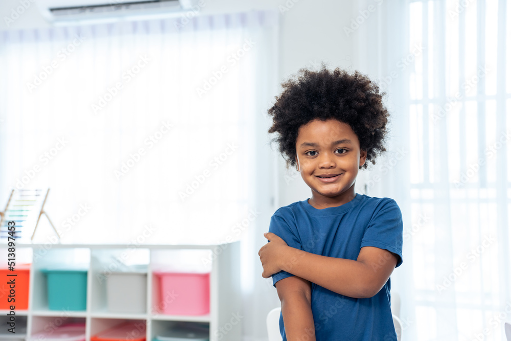 Portrait of African black child boy standing crossed arm in classroom. 