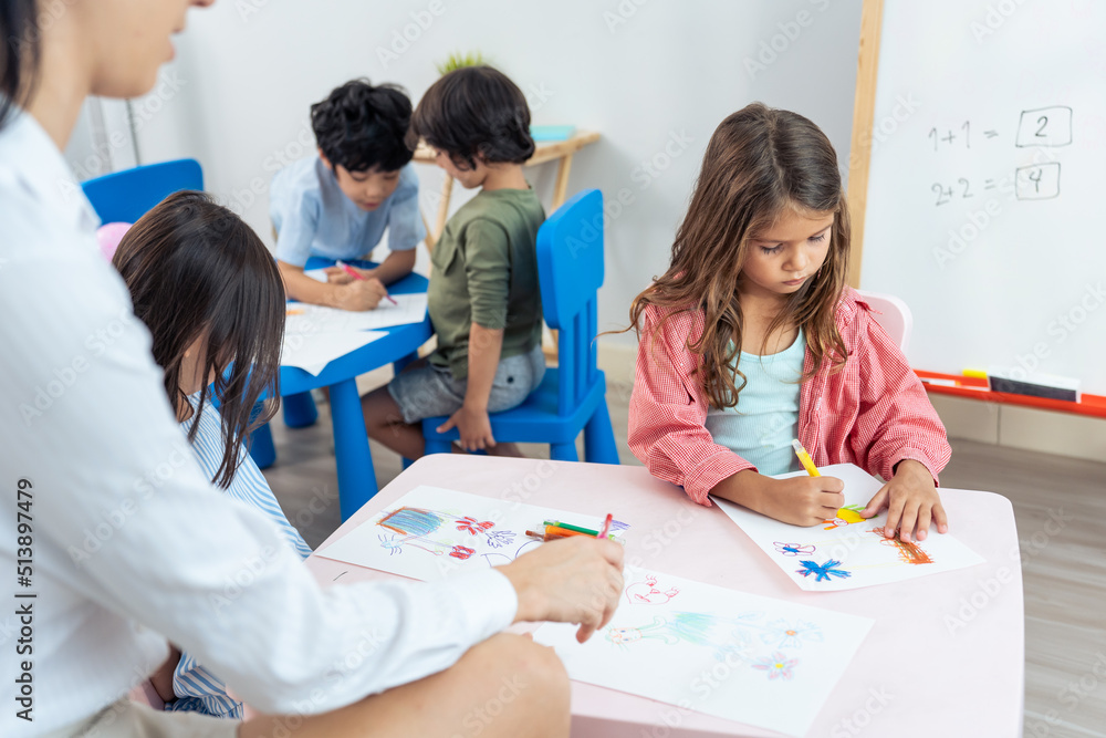 Caucasian beautiful woman teacher teaching a lesson to kid at school.