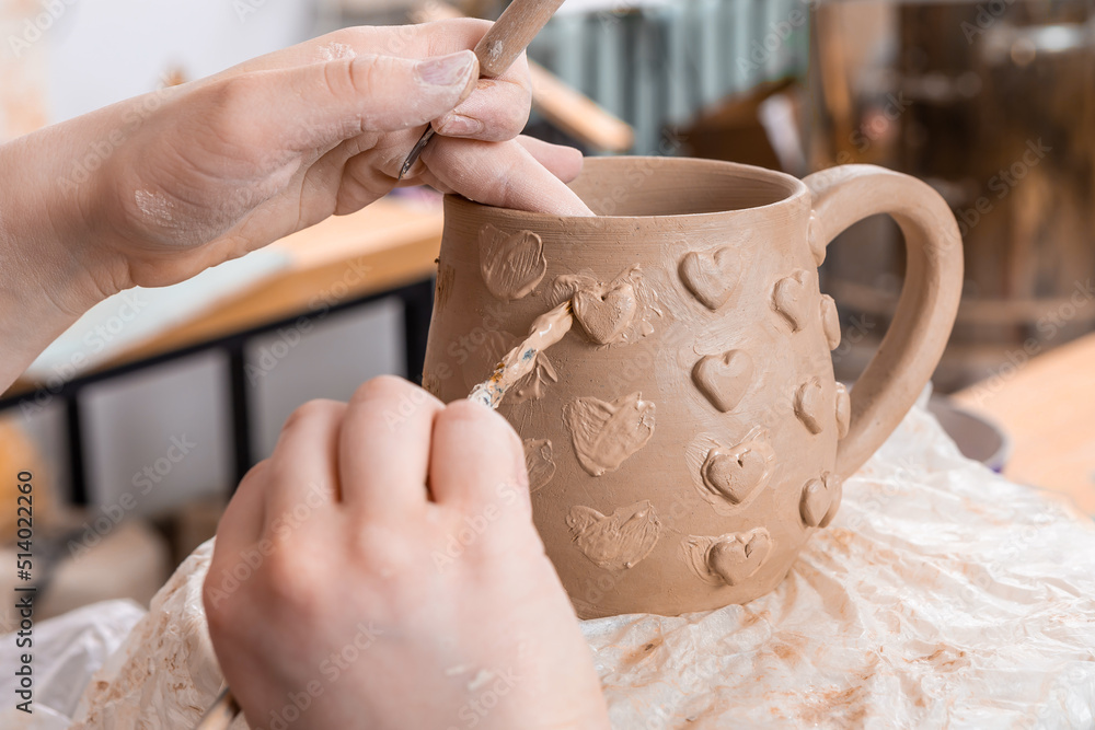 Professional ceramist creating handmade cup in studio