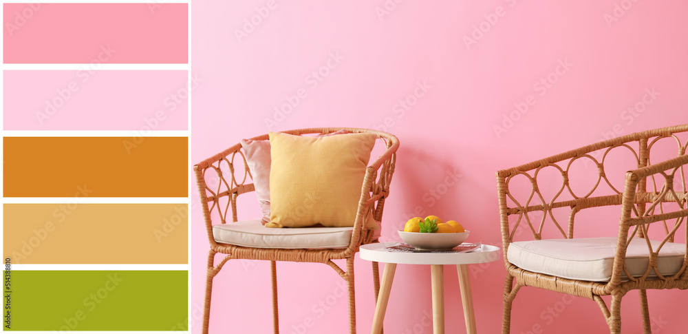 Comfortable wicker chairs and table near pink wall. Different color patterns