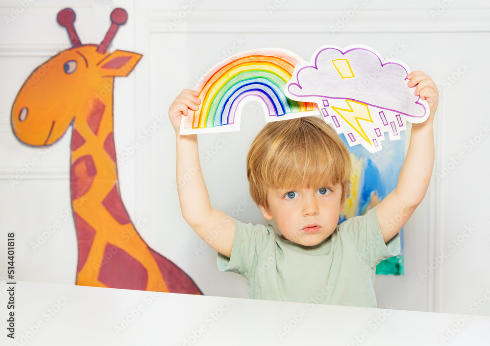 Boy in the class show weather cards with rain and rainbow