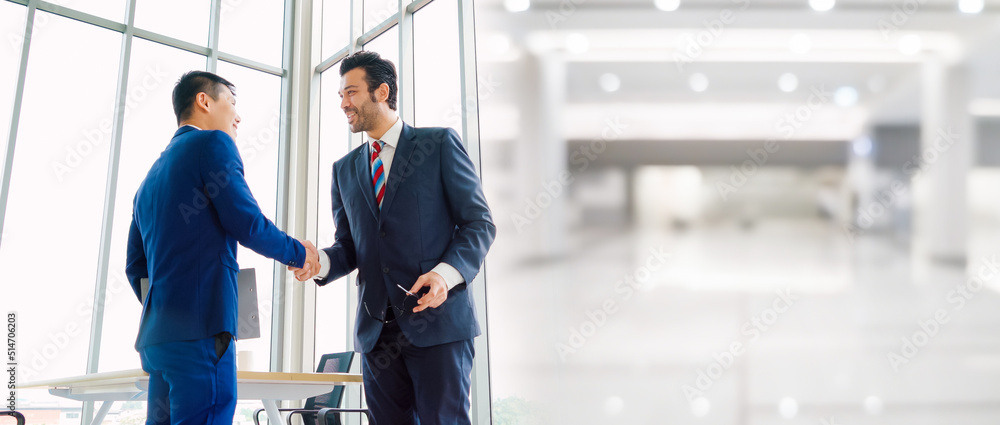 Business people handshake in corporate office in widen view showing professional agreement on a fina