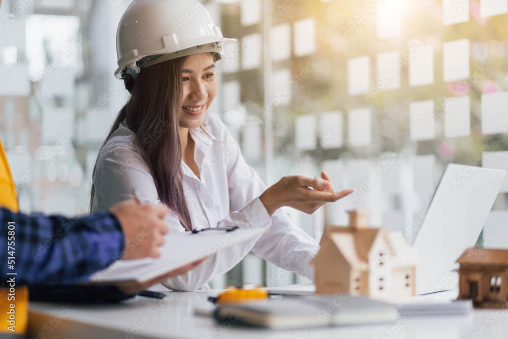 Happy female architect designer in the office works with her colleagues, engineers, contractors toge