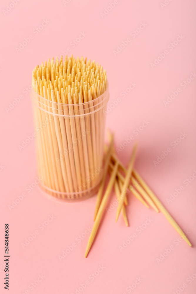 Box with toothpicks on pink background