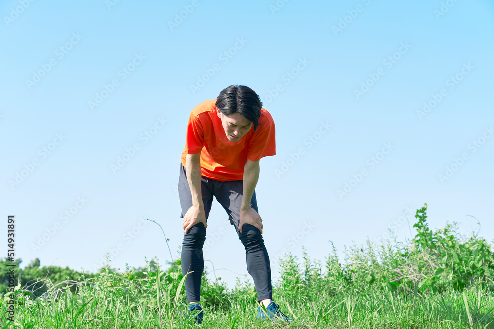 屋外で運動中に疲れる男性