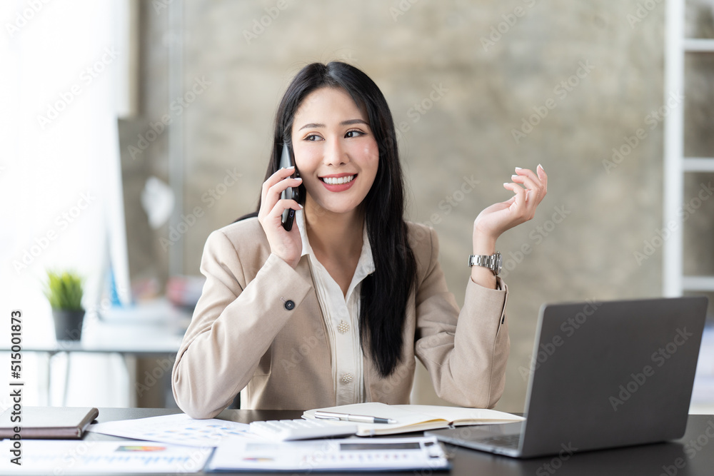 Asian businesswoman in formal suit in office happy and cheerful during using smartphone and working.