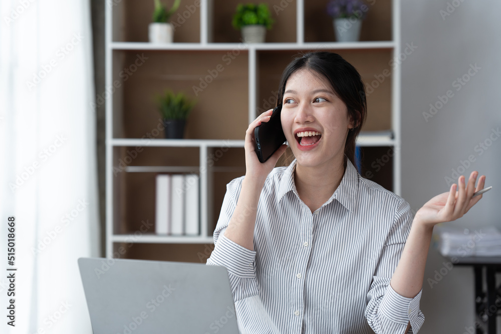 Asian businesswoman in formal suit in office happy and cheerful during using smartphone and working.