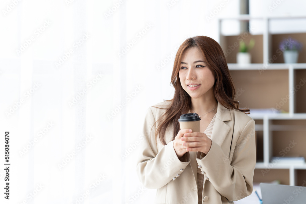 Happy asian business woman standing in modern office.