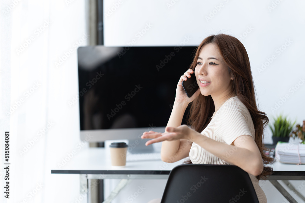 Asian businesswoman in formal suit in office happy and cheerful during using smartphone and working.