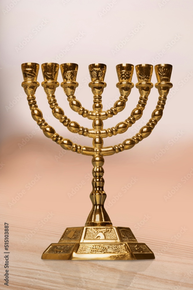 A classic gold menorah with a background of the walls