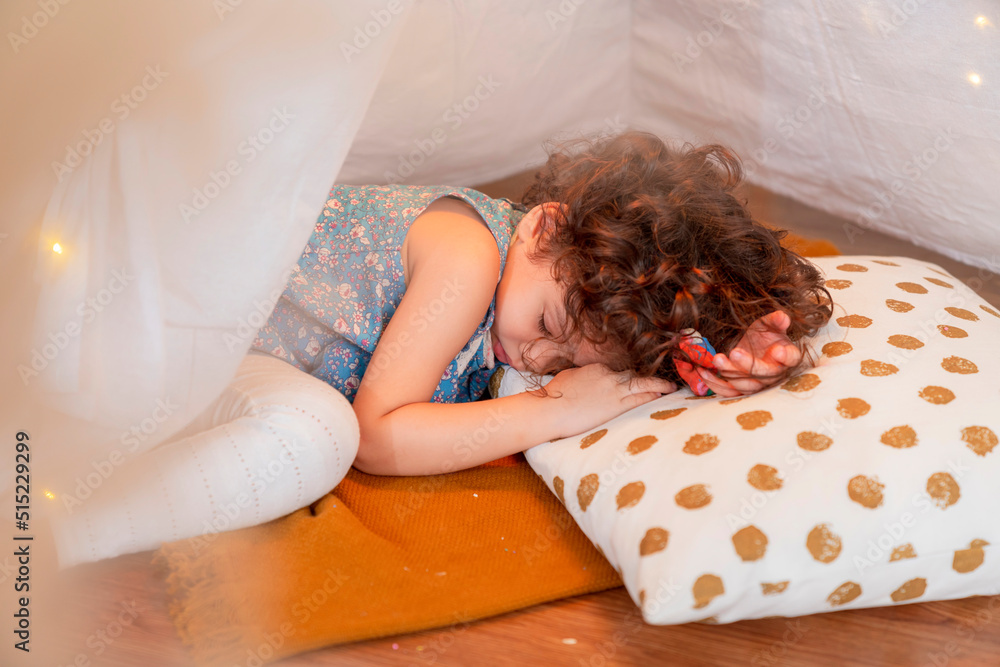 adorable white caucasian girl child fall in sleep on the floor after all day playing with her family