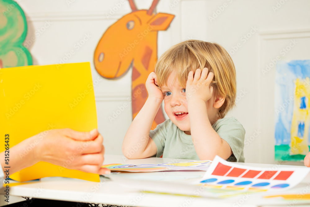 Boy in the class with thoughtful expression look at page