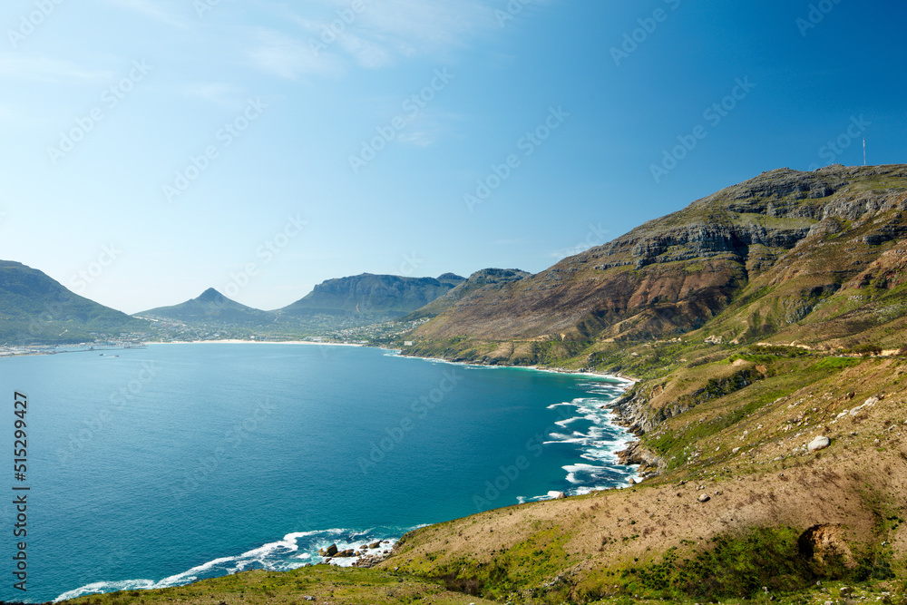 Panoramic view of the ocean surrounded by mountains from a hiking trail in Hout Bay, Cape Town in So