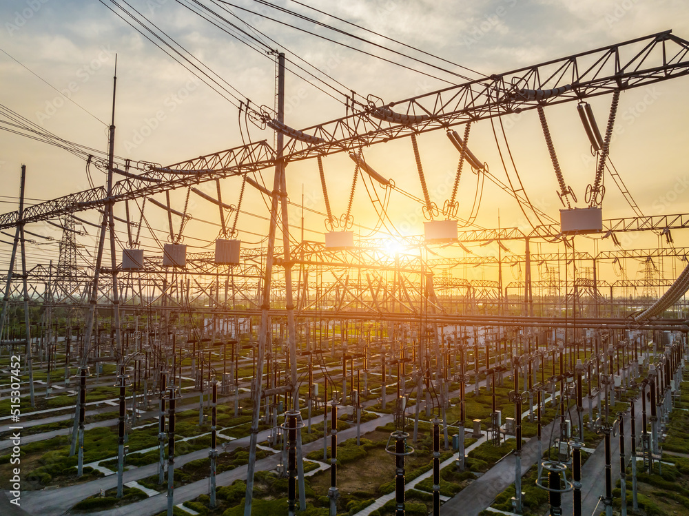 High voltage power tower in substation. Transmission power line. Electricity pylons and sky clouds b