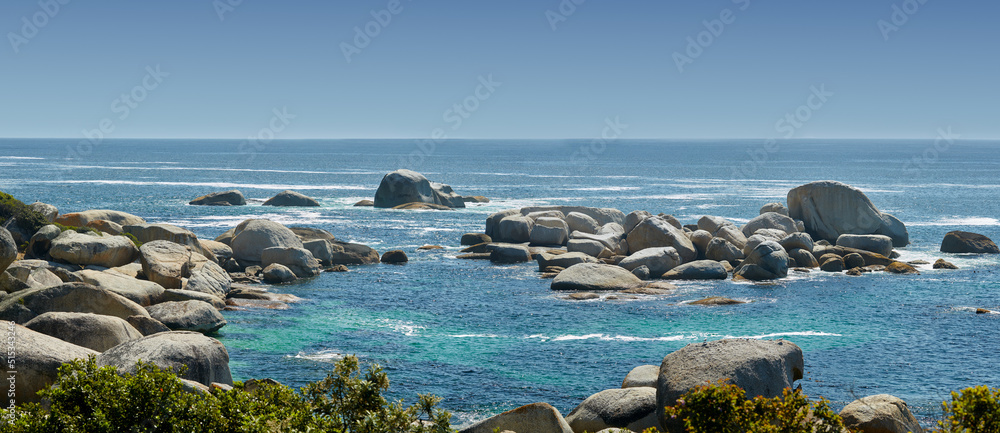 夏季海洋中的大型岩石景观。宽阔空旷的海边有许多石头。光滑的岩石