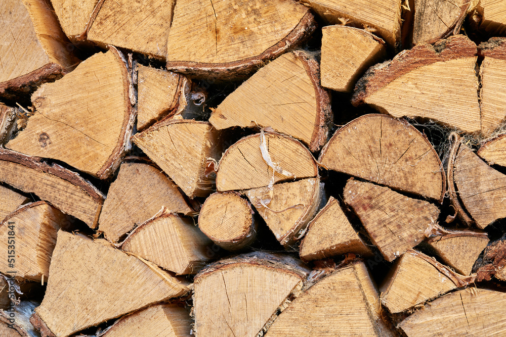 Above view of chopped firewood, logs stacked together in storage pile. Closeup of wooden background 