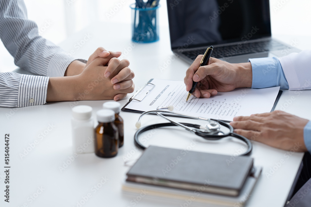 Doctor and patient sitting and talking at medical examination at hospital office, close-up. Therapis