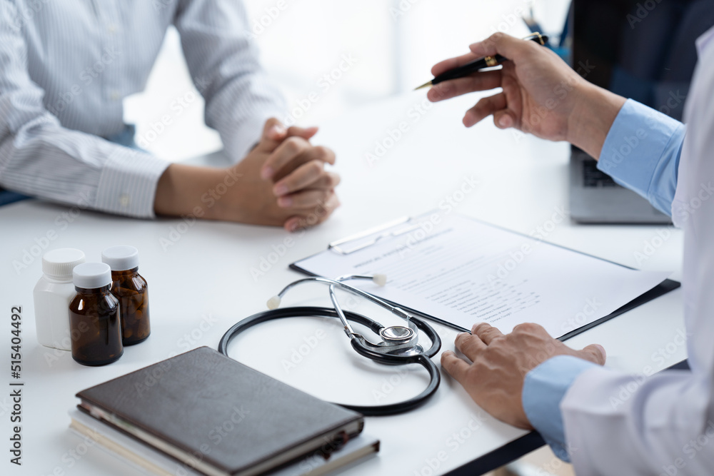 Doctor and patient sitting and talking at medical examination at hospital office, close-up. Therapis