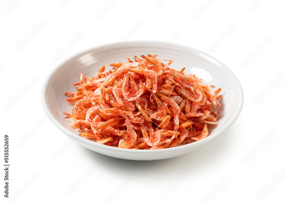 Dried sakura shrimps on a plate placed on a white background.