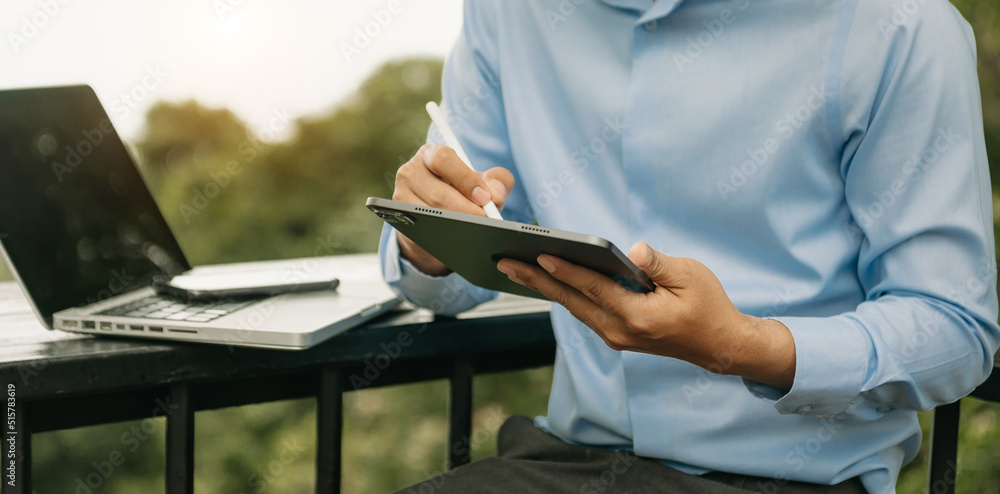 Business man hands is typing on a tablet and laptop at office or cafe