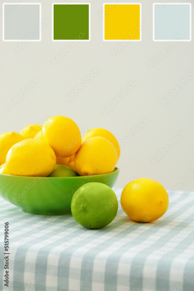 Bowl with ripe lemons and limes on table. Different color patterns