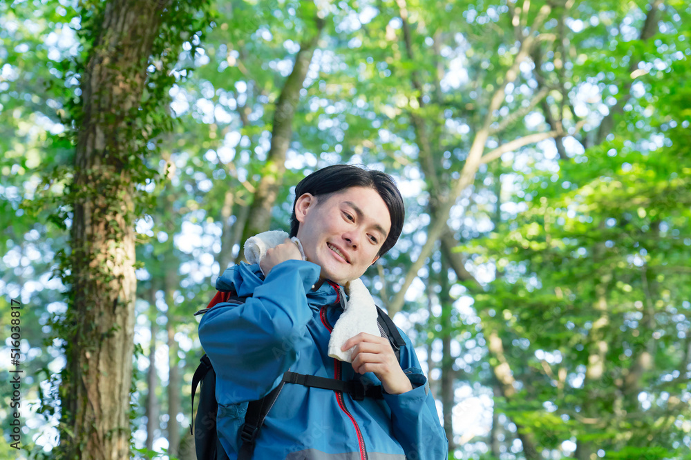 山登り中に汗を拭く男性