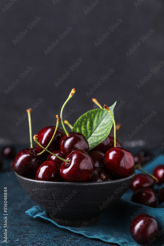 Bowl of ripe cherry on dark background