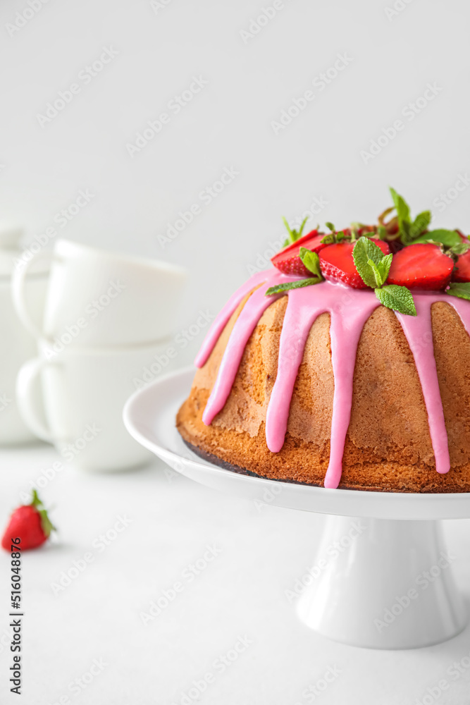 Dessert stand with tasty strawberry cake on light background