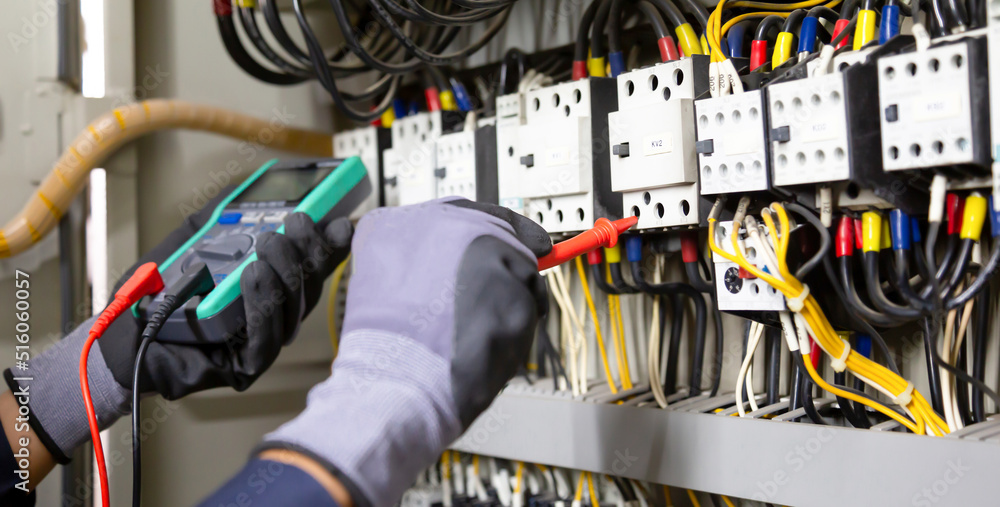 Electrician engineer tests electrical installations and wires on relay protection system. Adjustment