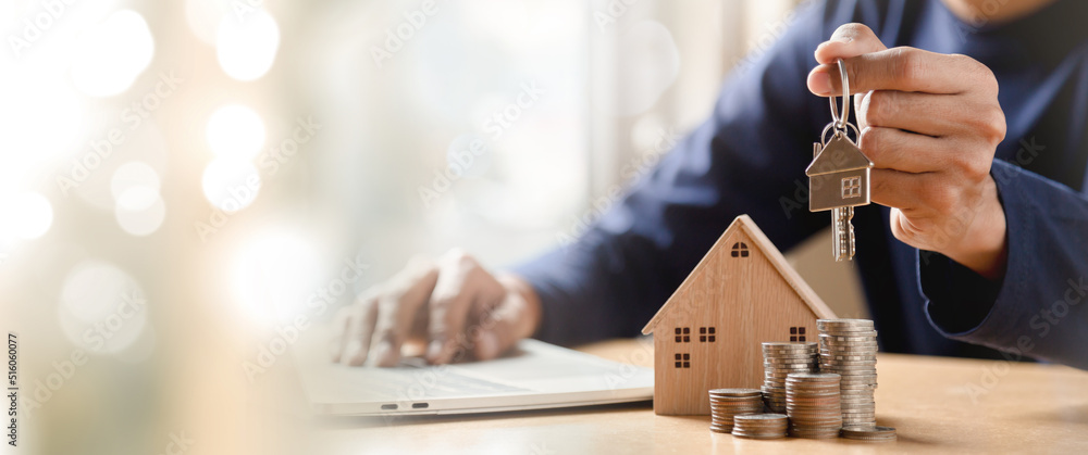 Men holding house model in hand and calculating financial chart for investment to buying property.