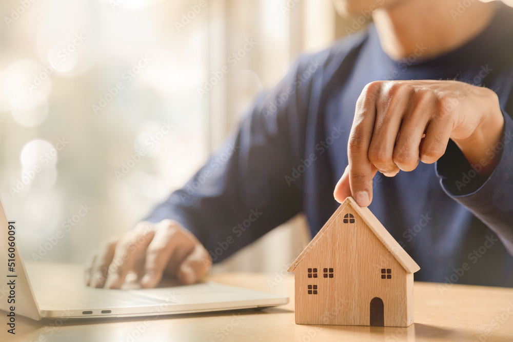 Men holding house model in hand and calculating financial chart for investment to buying property.