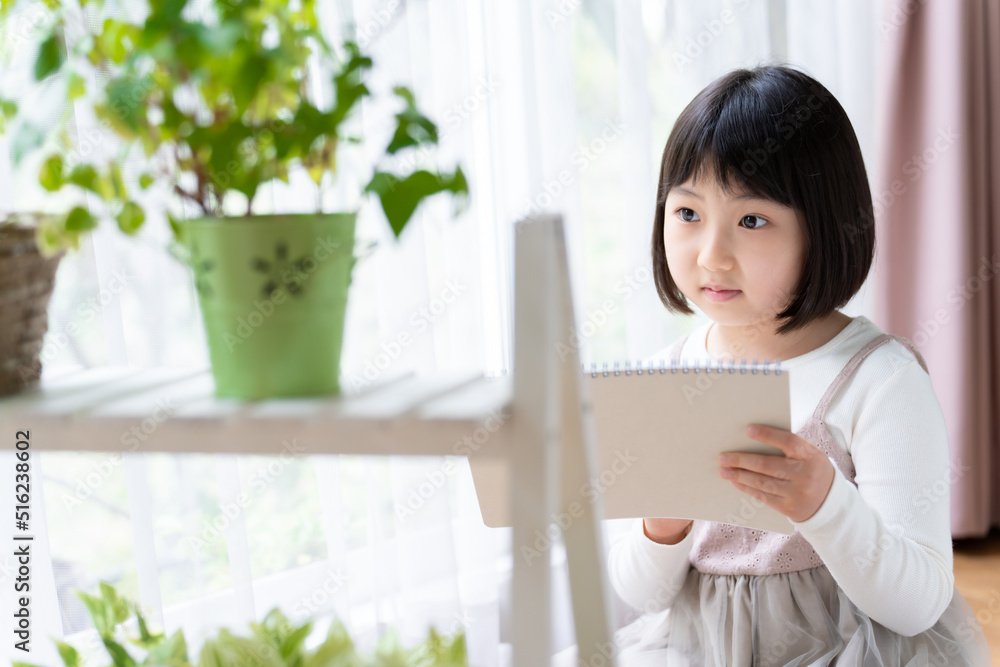 観葉植物の様子を記録する女の子