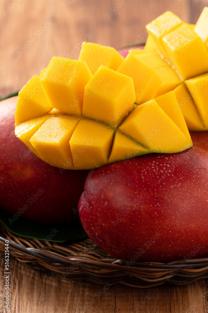 Mango. Fresh mango fruit with leaves over dark wooden table background.