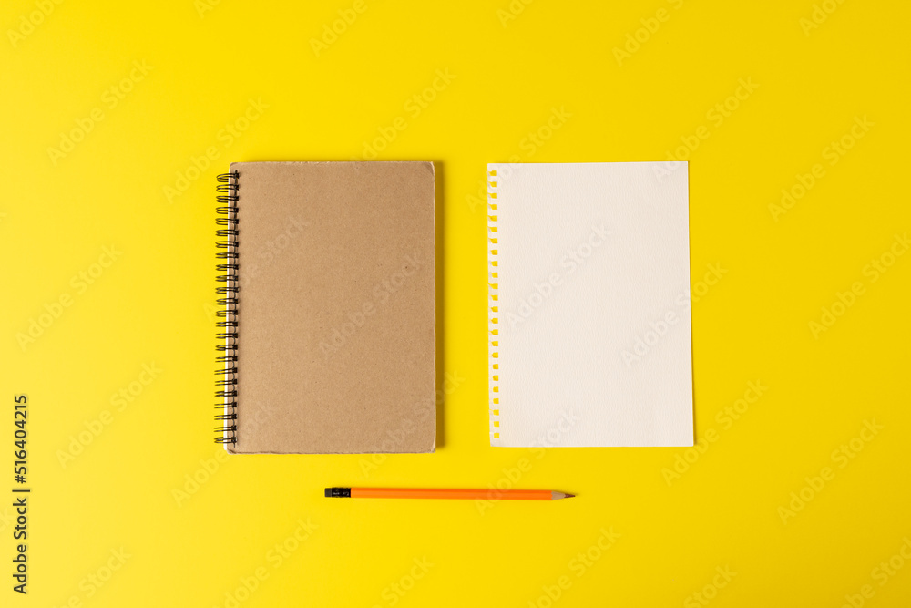 Composition of notebooks with copy space and pencil on yellow surface