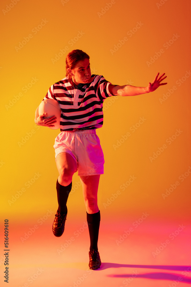 Caucasian female rugby player with rugby ball over neon pink lighting