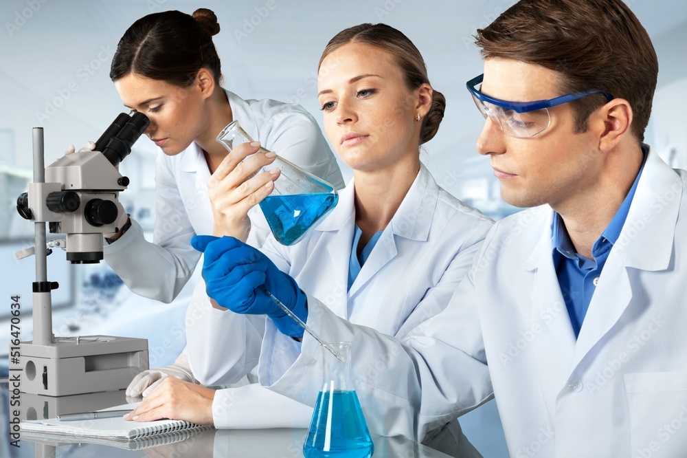 Young scientists conducting research investigations in a medical laboratory, a researcher in the for