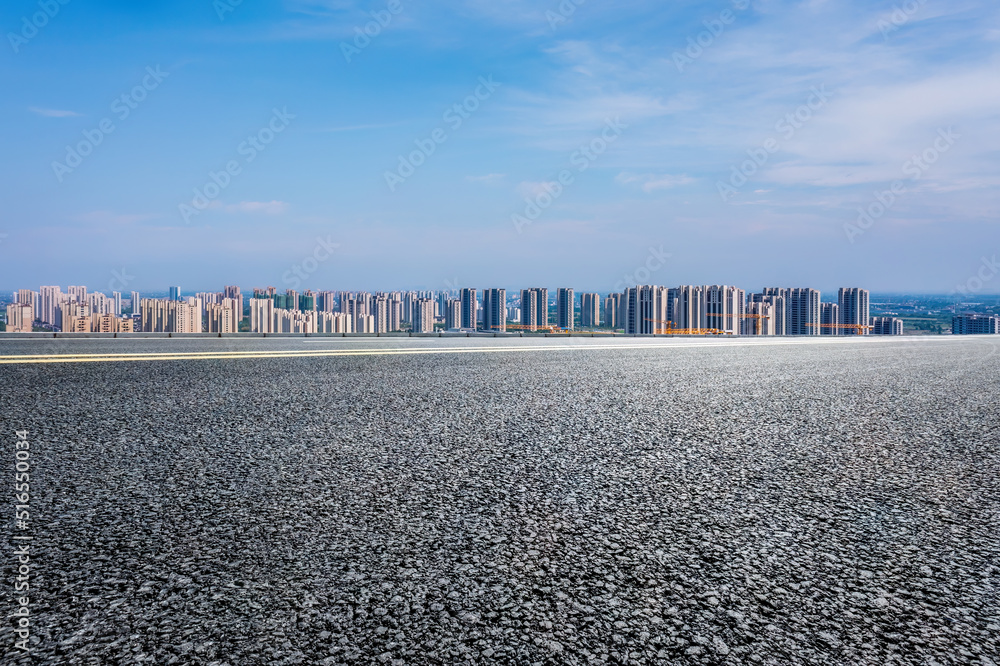 沥青路和现代城市天际线，建筑景观。高角度视野。