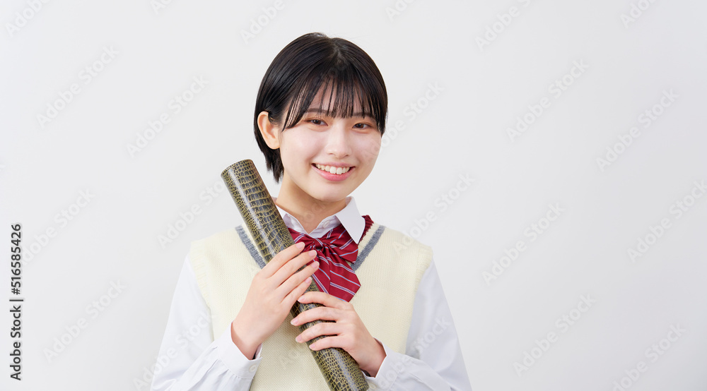 ワニ柄の筒を持つカメラ目線の笑顔の女子高生　白背景