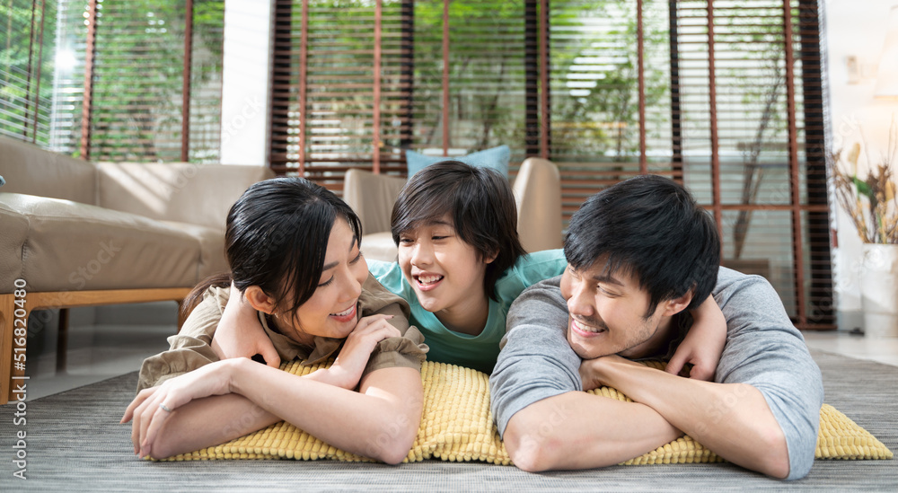 portrait of happy Asian family spending time together on sofa in living room. family and home concep