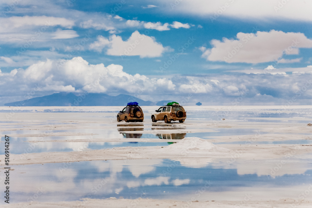 两辆车驶过玻利维亚最大的盐滩Salar de Uyuni。南美自然