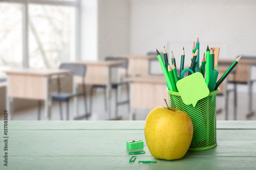 教室桌子上的一套学习用品和黄色苹果