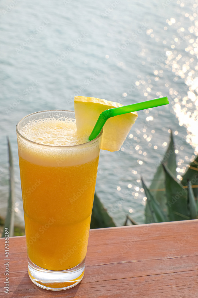 Glass of fresh tropical cocktail on table at sea resort