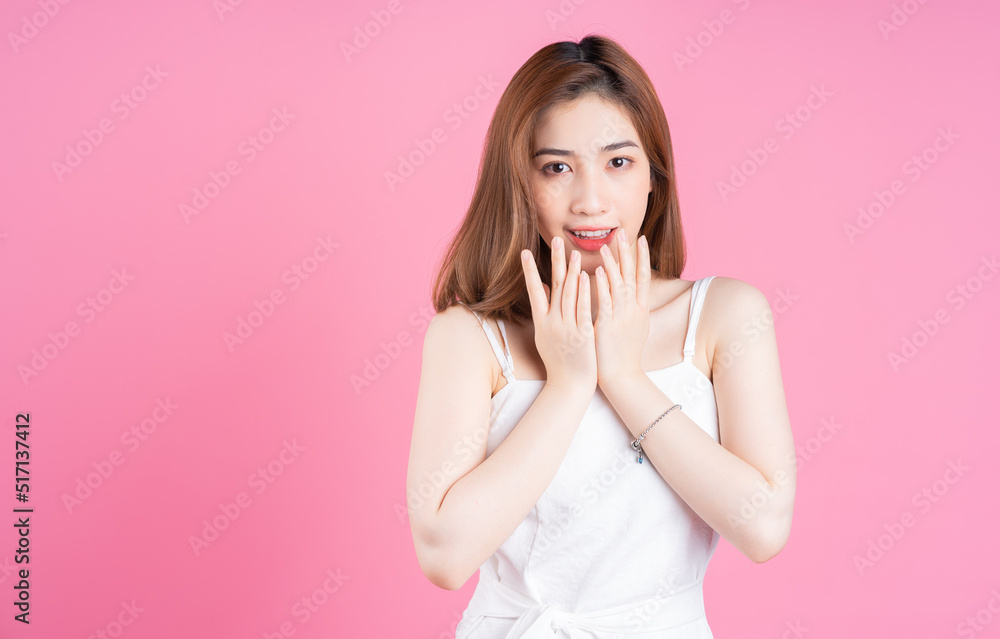 Image of young Asian woman posing on pink background