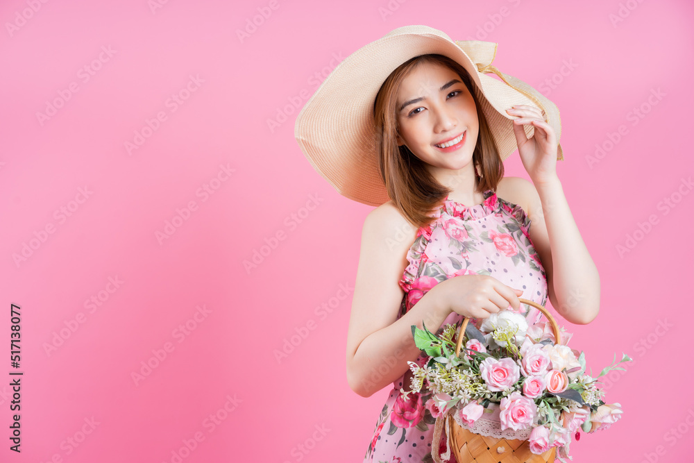 Photo of young Asian girl wearing flower dress on pink background